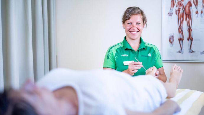 Therapeutin testet Nerven am Fuß einer Patientin