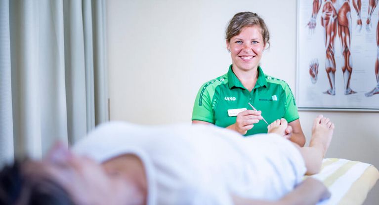 Werde Teil unseres Teams. Bewirb dich jetzt.  Therapeutin testet Nerven am Fuß einer Patientin